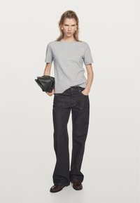 Szary t-shirt z krótkim rękawem, ciemnoniebieskie szerokie dżinsy, trzymając czarną torbę, brązowe buty, gładki materiał, podstawowy wzór, dopasowany krój.