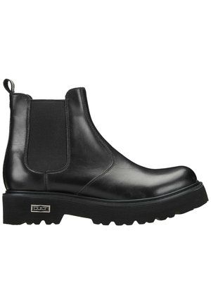 Stivale Chelsea in pelle nera con pannelli laterali elasticizzati, punta arrotondata e suola in gomma spessa con texture rigata. Dettaglio del logo sulla suola.
