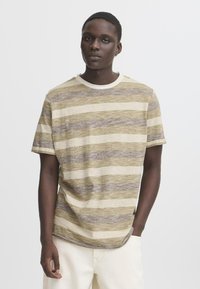Kortermet, crew-neck t-skjorte med horisontale striper i beige, oliven og brune nyanser. Myk tekstur og avslappet passform, buet kant.
