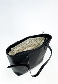 Zwarte leren schoudertas met een ritsluiting, een gestreepte binnenvoering en twee handvatten. Bevat een gouden ritsvak aan de binnenkant.