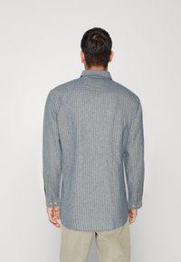 Blue striped long-sleeve shirt with a spread collar, button cuffs, and curved hem, made of lightweight fabric.