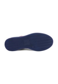 Shoe sole in navy blue rubber with a wavy tread pattern. Features a branded logo embossed in the center. Solid and textured for grip.