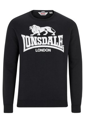 Svart sweatshirt i bomull med långa ärmar. Har en stor vit grafisk logotyp som säger "Lonsdale London" och en lejon-siluett.