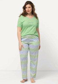 Camiseta de algodón verde con el texto "Sparkle Dreams" en piedras de strass, combinada con pantalones de pijama estampados en un diseño de olas azules y verdes.