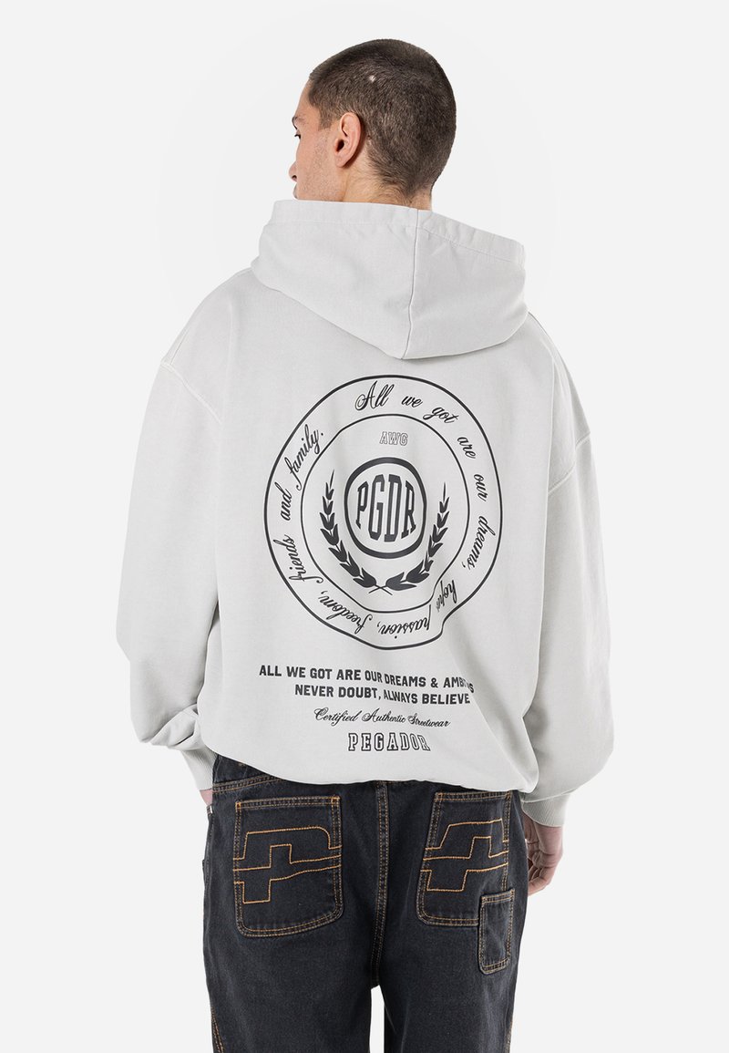 Felpa con cappuccio grigio chiaro e vestibilità oversize. Presenta un grande design grafico nero sul retro, dettagli testuali e polsini larghi.