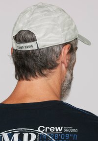 Lichtgrijze baseballcap met een subtiele textuurpatroon, voorzien van een verstelbare band en "CAMP DAVID" geborduurd op de achterkant.
