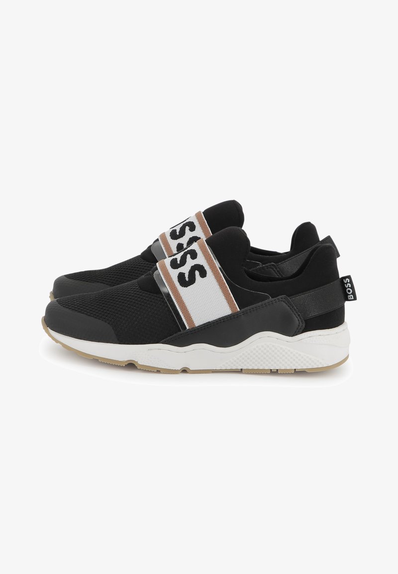 Sapatos desportivos pretos com parte superior em malha, apresentando uma ampla faixa branca com letras pretas, detalhes em castanho e uma sola branca texturizada.