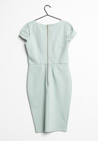 Robe ajustée bleu clair, longueur genoux, avec manches courtes et fermeture éclaire visible au dos, suspendue sur un cintre noir contre un fond blanc.
