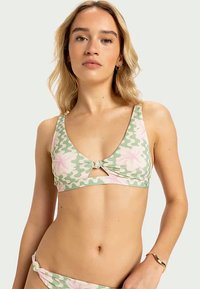 Bloemenbikini-top met een groen camouflagepatroon, v-vormig ontwerp, lichtgewicht stof en een knoopdetail in het midden.