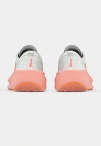 Αθλητικά παπούτσια με λείο λευκό επάνω μέρος, πορτοκαλί λεπτομέρειες και παχύ κοραλλί ενδιάμεσο πέλμα. Διαθέτουν υφασμένο πάτο και θηλιά για εύκολο φόρεμα.