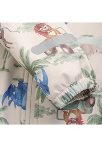Veste pour enfants avec un fond blanc présentant des illustrations d'animaux colorés. Manches élastiques et texture de tissu lisse et léger.