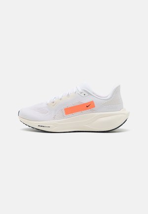 Zapatilla deportiva blanca con parte superior de malla transpirable, acento naranja vibrante, suela acolchada y suela texturizada para mayor tracción.