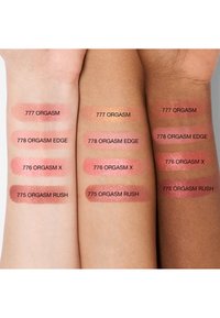 Trois avant-bras de différentes carnations montrent quatre échantillons de blush rose étiquetés : 777 Orgasm, 778 Orgasm Edge, 776 Orgasm X, 775 Orgasm Rush.