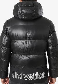 Doudoune noire avec une finition brillante, capuche oversize et coutures horizontales. Comprend une ceinture noire avec l'inscription "Helvetica".