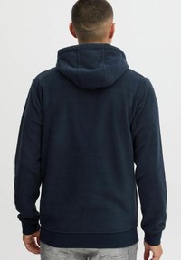 Navy fleece hoodie with a relaxed fit, adjustable drawstring hood, and ribbed cuffs. Soft texture with no visible patterns or accents.