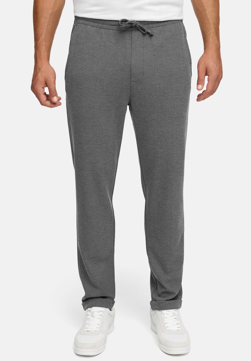 Grå joggebukser laget av mykt stoff, med elastisk midje med snor, sidelommer og smalna ben.