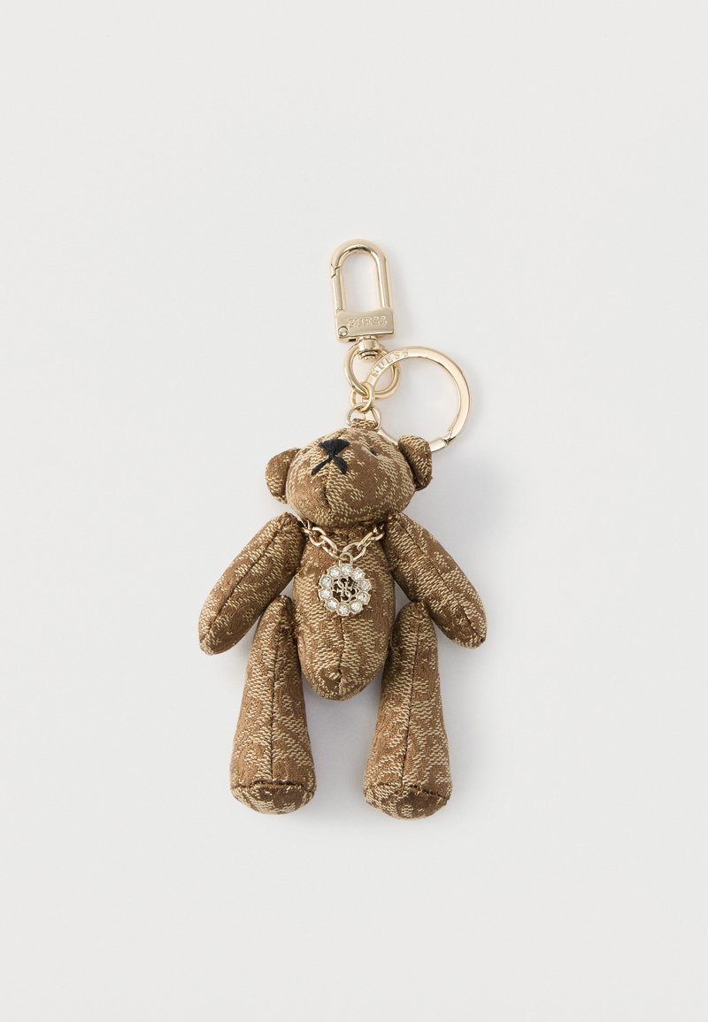 Brązowy brelok do kluczy w kształcie misia z tkaniny, z elementami w kolorze złotym, wyposażony w łańcuszek i ozdobę z kryształków wokół szyi. Powierzchnia o fakturze.