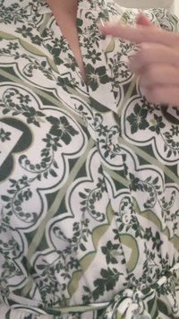 Grønn og hvit blomstermønstret omslagskjole med korte ermer, med V-hals, knapper og en knyttet midje.