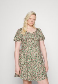 Vestido floral com decote quadrado. Apresenta mangas bufantes e uma bainha rodada. O material é leve, com fundo verde e flores rosas.