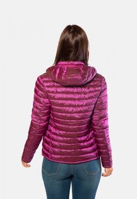 Doudoune violette avec capuche, présentant une finition brillante et matelassée, ainsi que des poignets élastiques. La vue arrière montre un design ajusté et une longueur au niveau de la taille.