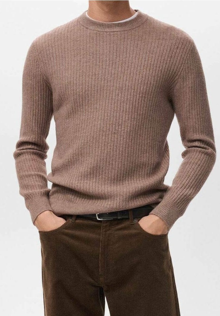 Homme portant un pull léger en tricot côtelé marron clair à manches longues et un pantalon en velours côtelé marron foncé, les mains dans les poches.
