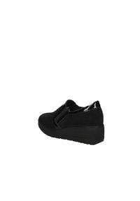 Scarpe con tacco a cuneo nere con una combinazione di camoscio e dettagli lucidi in vernice. Il design slip-on presenta pannelli elastici laterali e una superficie texture.