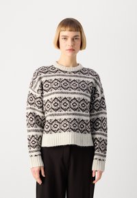 Maglione lavorato a maglia in crema e marrone, caratterizzato da motivi geometrici. Collo e polsini a costine, vestibilità rilassata, texture morbida.