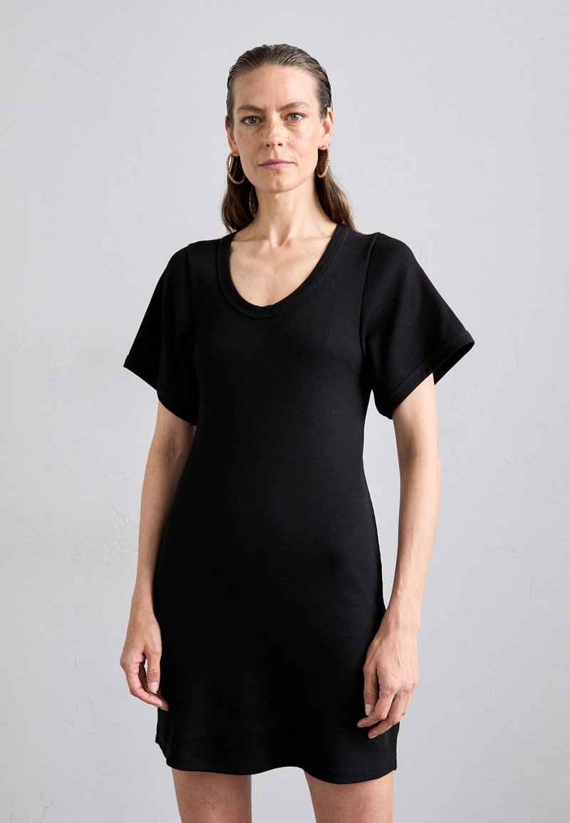 Schwarzes, geripptes Kleid mit V-Ausschnitt, kurzen Ärmeln und einer figurbetonten Silhouette. Der Stoff wirkt weich mit einer leichten Textur.