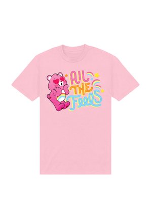 Lyserød T-shirt med et grafik af en bjørn med hjerteformede øjne, omgivet af teksten "All The Feels" i farverig, legende skrifttype.