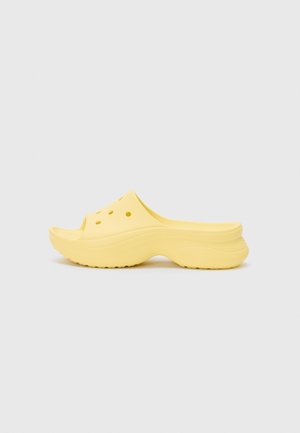 Sabot jaune à enfiler avec une semelle épaisse et des trous de ventilation sur la tige, présenté de profil sur un fond neutre.