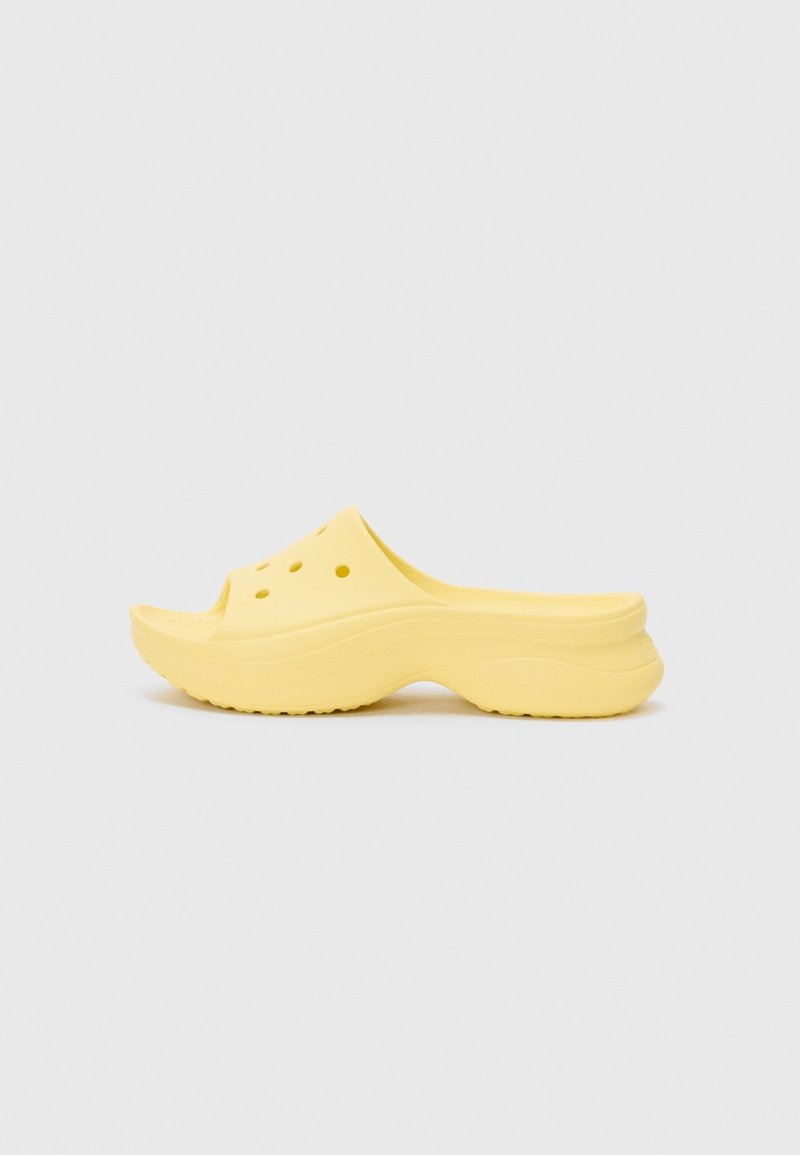 Sabot jaune à enfiler avec une semelle épaisse et des trous de ventilation sur la tige, présenté de profil sur un fond neutre.