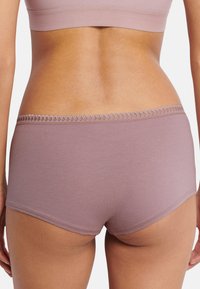 Bomuldsshorts i blød mauve med en dekorativ blonderkant i taljen. Glat tekstur og tætsiddende design med en midt-høj talje.