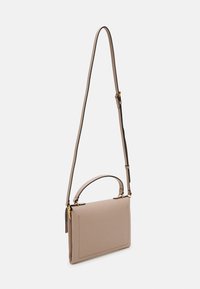 Beige leather crossbody bag with a top handle, adjustable strap, gold hardware, and stitched detailing. Smooth texture and rectangular shape.