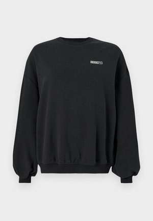 Crni oversized dukserica s dugim napuhanim rukavima i malim "ROSIE" logotipom s Puma brandingom na lijevoj strani prsnog koša.