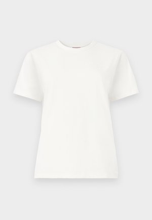 Tricou alb cu mâneci scurte și guler rotund, cu un logo subtil brodat în partea superioară stângă a pieptului, pe un fundal simplu gri deschis.