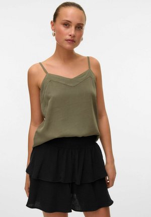 Haut sans manches, vert olive, avec un décolleté en V, associé à une jupe noire à étages avec volants et une taille élastique.