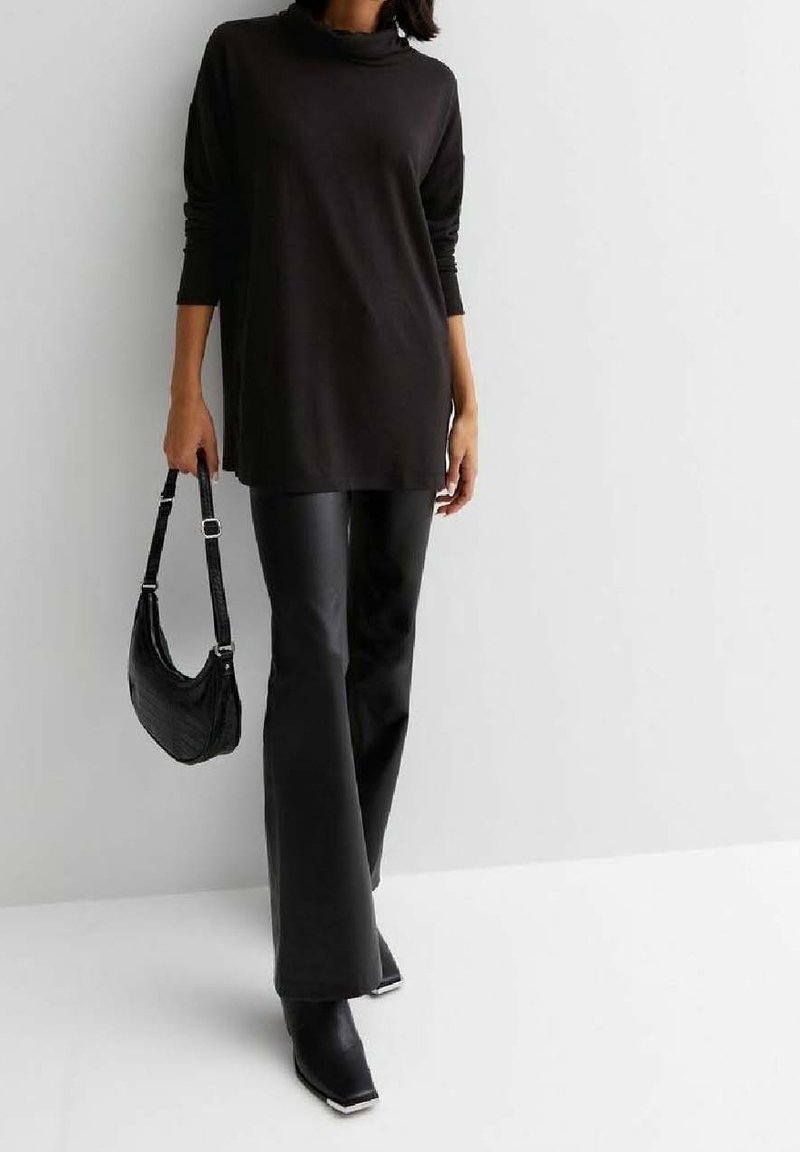 Black long-sleeve top with a high neck, paired with black flared faux leather pants and a textured black shoulder bag. Heeled black boots.