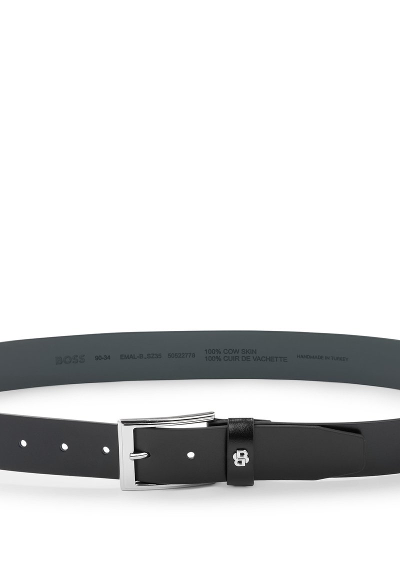 Ceinture noire en cuir de vache avec une boucle en argent. Présente une finition texturée et plusieurs trous pour l'ajustement. Fabriquée à la main en Turquie.