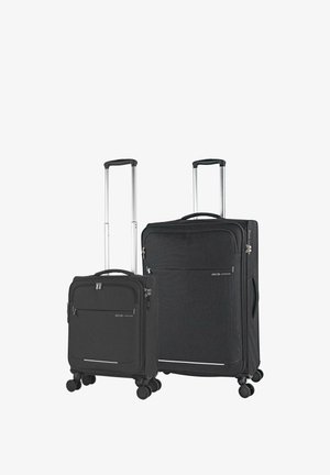 Dos maletas negras de carcasa blanda con asas telescópicas y cuatro ruedas giratorias, una más pequeña y otra más grande, situadas una al lado de la otra.