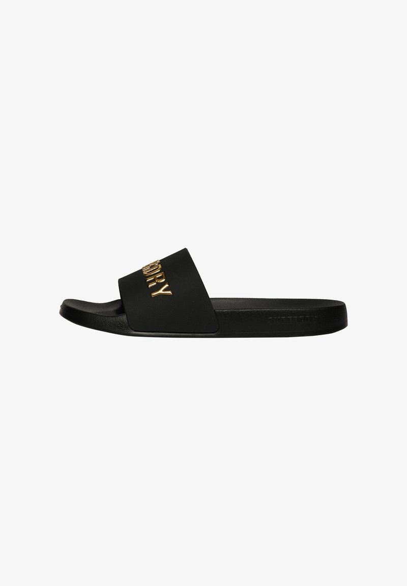 Black slide sandal with a smooth rubber upper featuring a gold embossed logo. Flat sole with minimal arch and a wide strap for comfort.