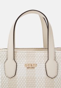 Borsa a tracolla beige intrecciata con dettagli in pelle crema e forma strutturata. Presenta un logo dorato e due manici robusti per il trasporto.