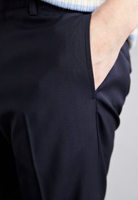 Marinebukser med glat stof, lige skæring, åbne sidelommer og diskrete sømdetaljer.