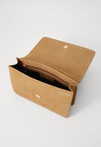 Clutch in suede tan con texture liscia, dotato di chiusura magnetica e di una tasca interna con zip. Le dimensioni chiuse sono rettangolari.