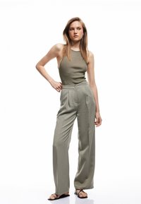 Khaki vidde bukser med frontfolder og en matchende ribbet tanktop. Glat stof og minimal detaljering forbedrer det samlede look.