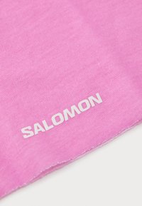 Roza tkanina s glatkom teksturom, s imenom brenda "SALOMON" u bijelom slovu; rubovi su uredno šivani.