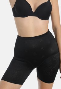 Schwarze Shapewear-Shorts mit glatter Textur, die ein florales Muster in einem dunkleren Farbton aufweisen. Hoch geschnittenes Design reicht bis zur Mitte des Oberschenkels.