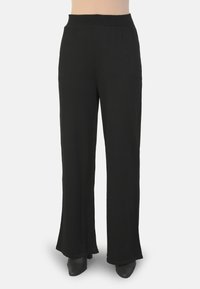 Zwarte, wijde broek met een elastische tailleband. Gemaakt van zachte stof, met een gladde textuur en een simpele, strakke silhoutte.