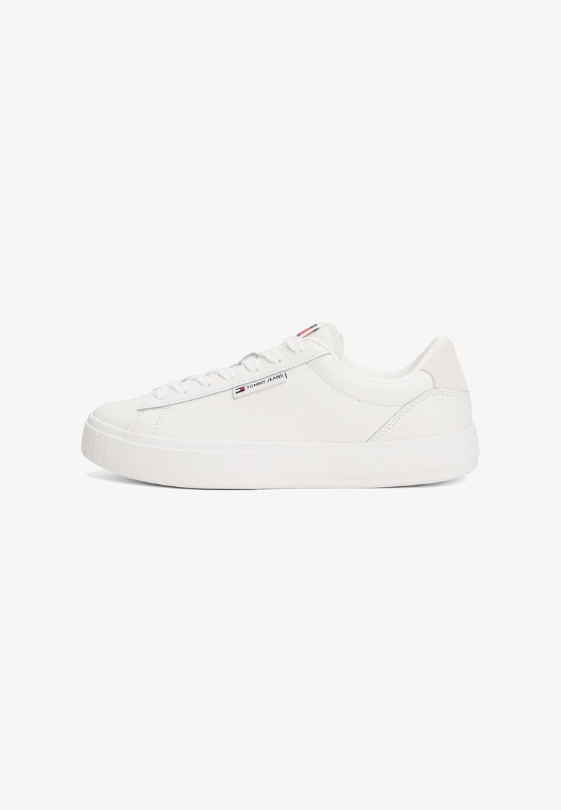 White sneaker with a smooth leather upper, flat lace closure, and textured rubber sole. Features a small logo tag on the side.