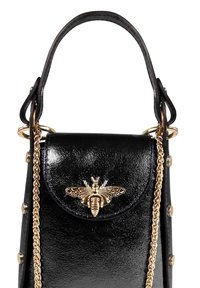 Sac à main en cuir noir avec une finition brillante, orné d'un accent en forme d'abeille dorée, d'une bandoulière en chaîne et de clous décoratifs sur les côtés.