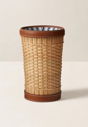 Tkaný ratanový odpadkový kôš s hnedou koženou obrubou, ktorý má hladký povrch a vzorovanú modro-bielu vnútornú podšívku.